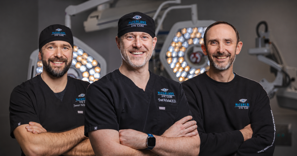Three experienced ophthalmologists from McFarland Eye Care stand together in a modern surgical suite, specializing in cataract surgery, LASIK, refractive lens exchange, and advanced vision correction in Arkansas.