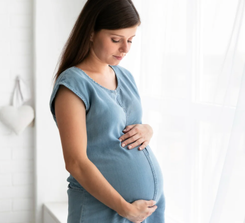 Pregnant woman holding her belly, representing hormonal changes that can affect vision