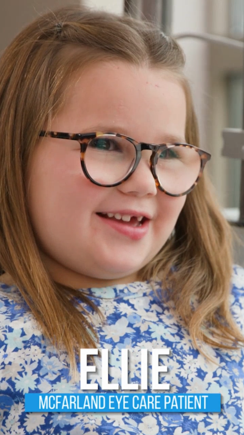 Young girl wearing eyeglasses and smiling during a pediatric eye care visit at McFarland Eye Care.