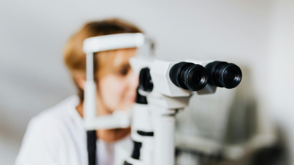 Eye doctor performing a detailed eye exam using specialized diagnostic equipment to evaluate dry eye symptoms and eye allergies.