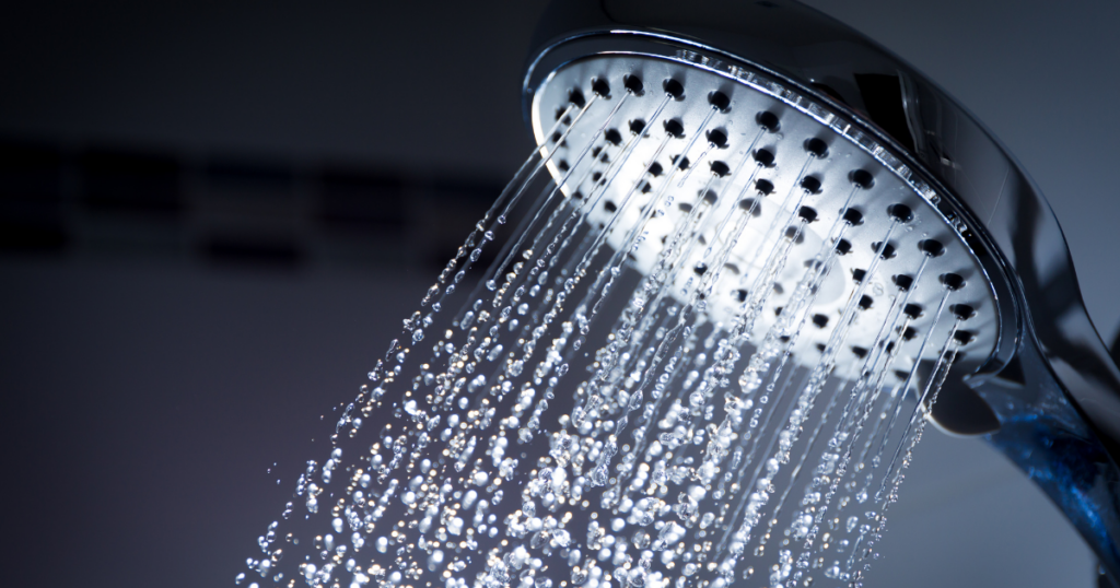 Water flowing from a showerhead, illustrating why contact lenses should be removed before showering.